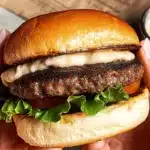 Mushroom-beef blended burger recipe with toasted brioche bun, fresh lettuce, and creamy cheese sauce