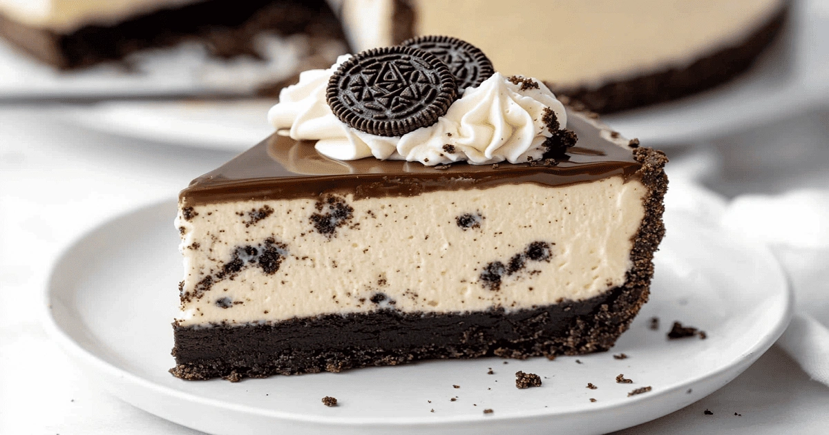 clean slice of Oreo cheesecake with ganache and whipped cream on a white plate