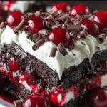 Black Forest poke cake slice with cherries and whipped topping