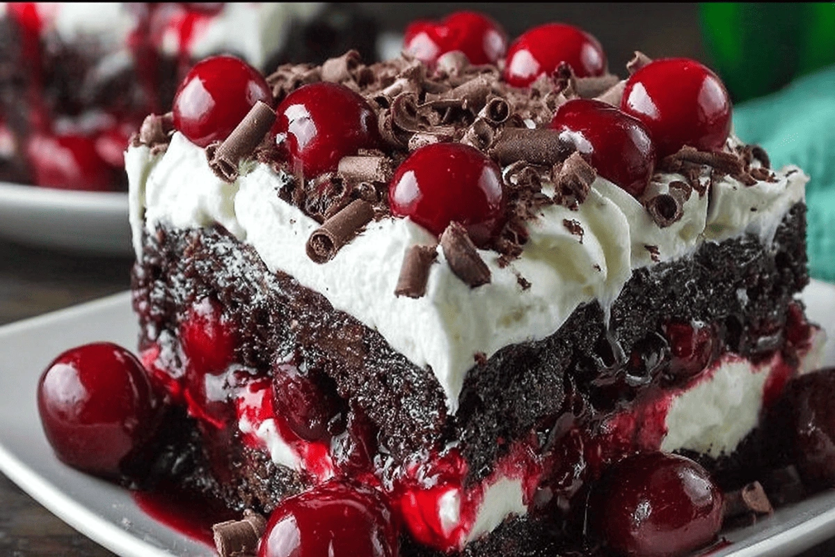 Black Forest poke cake slice with cherries and whipped topping