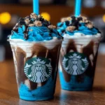 Blue Cookies & Cream Dip Frappuccinos topped with whipped cream, crushed cookies, and chocolate drizzle in Starbucks-style cups