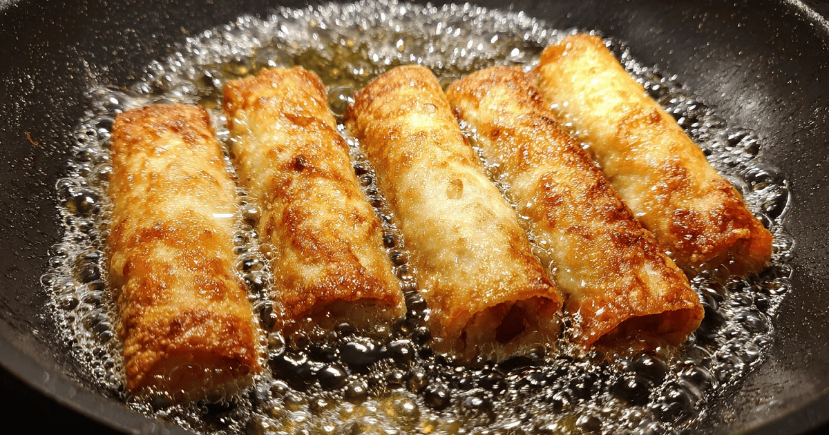 Frying cherry cheesecake egg rolls until golden brown