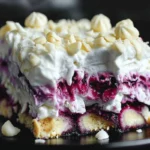 No-Bake Blueberry Cream Cheesecake Lasagna slice topped with whipped cream and white chocolate curls