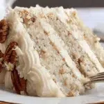 Slice of Snowy Bavarian Bliss Cake with coconut-pecan frosting and creamy white layers