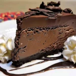 Slice of Chocolate Fudge Truffle Cheesecake with ganache topping, whipped cream, and chocolate drizzle