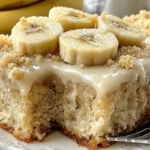 Moist banana bread bars topped with brown butter frosting and fresh banana slices