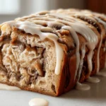 Cinnamon roll banana bread sliced with maple glaze dripping