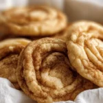 Cinnamon roll cheesecake cookies with golden cinnamon swirls and creamy filling