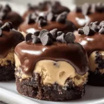 close-up of chocolate chip cookie dough brownie bites with fudgy brownie base, edible cookie dough layer, and glossy chocolate ganache topped with mini chocolate chips