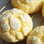 soft heavenly lemon cookies with powdered sugar crinkle on a cooling rack