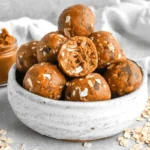 bowl of pumpkin protein balls with oats and cinnamon sticks